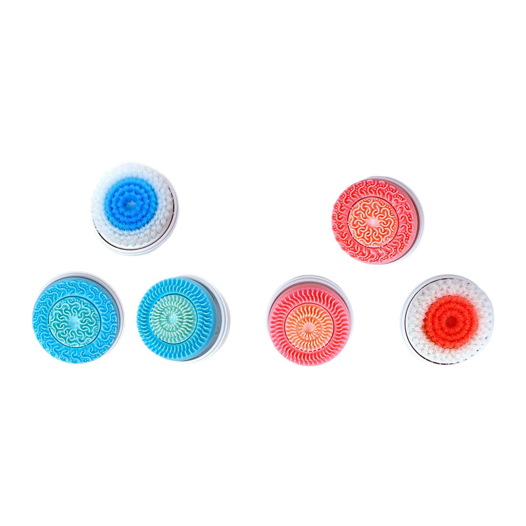 Five round, colorful facial cleansing brush heads with varying bristle and silicone textures on a white background.