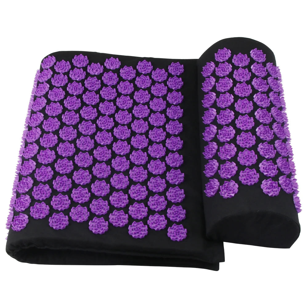 Black acupressure mat and neck pillow set with purple plastic lotus-shaped spikes on a white background.