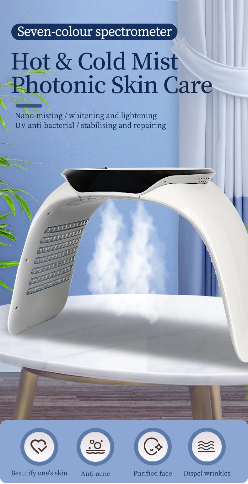White arched LED light therapy machine emitting mist for facial skin care treatments, set on a white marble table.