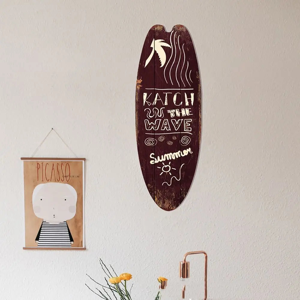 Wood surfboard hanging sign with dark maroon finish and “KATCH the WAVe” beach text