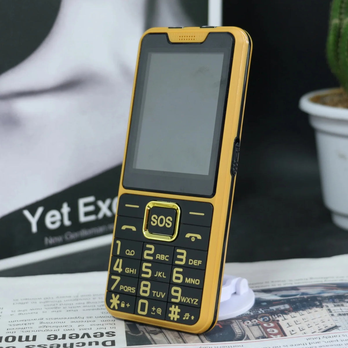 Yellow senior feature phone with SOS key and keypad, front screen turned on