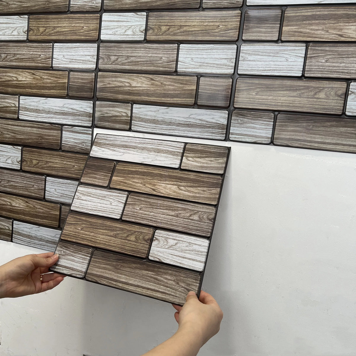 Wood-look peel-and-stick tile backsplash squares in gray, white, and brown, interlocking