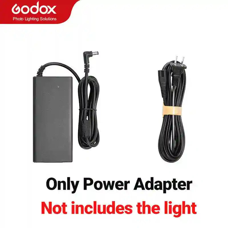 Black power adapter block with attached barrel plug cable and a separate detachable power cord with US wall plug.