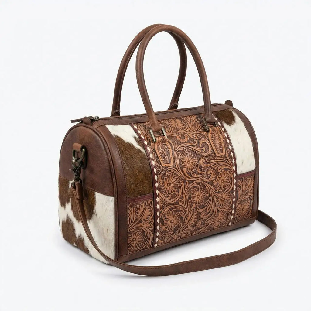 Genuine leather mini duffel with floral tooling and brown/white cowhide panels, zipper closure, and shoulder strap.