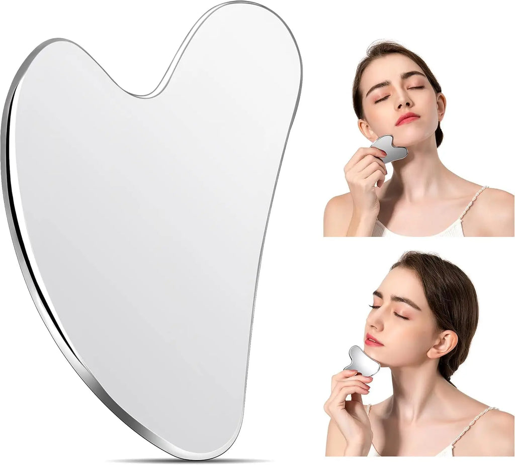 A polished, heart-shaped stainless steel Gua Sha tool, shown alone and being used to massage a woman's jawline.