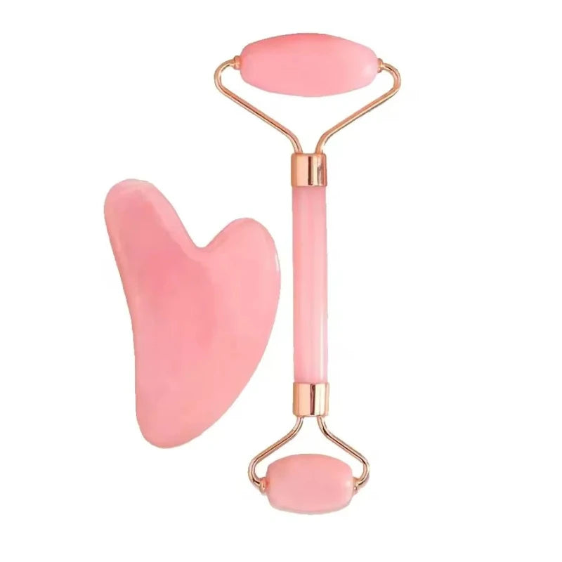 A pink rose quartz double-ended face roller and a heart-shaped gua sha tool with gold-tone metal accents.