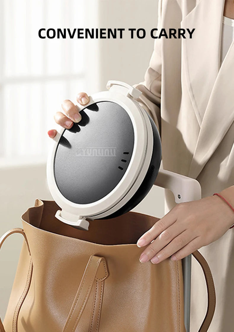Portable electric cooking pot with carry handle and black lid, shown on white base