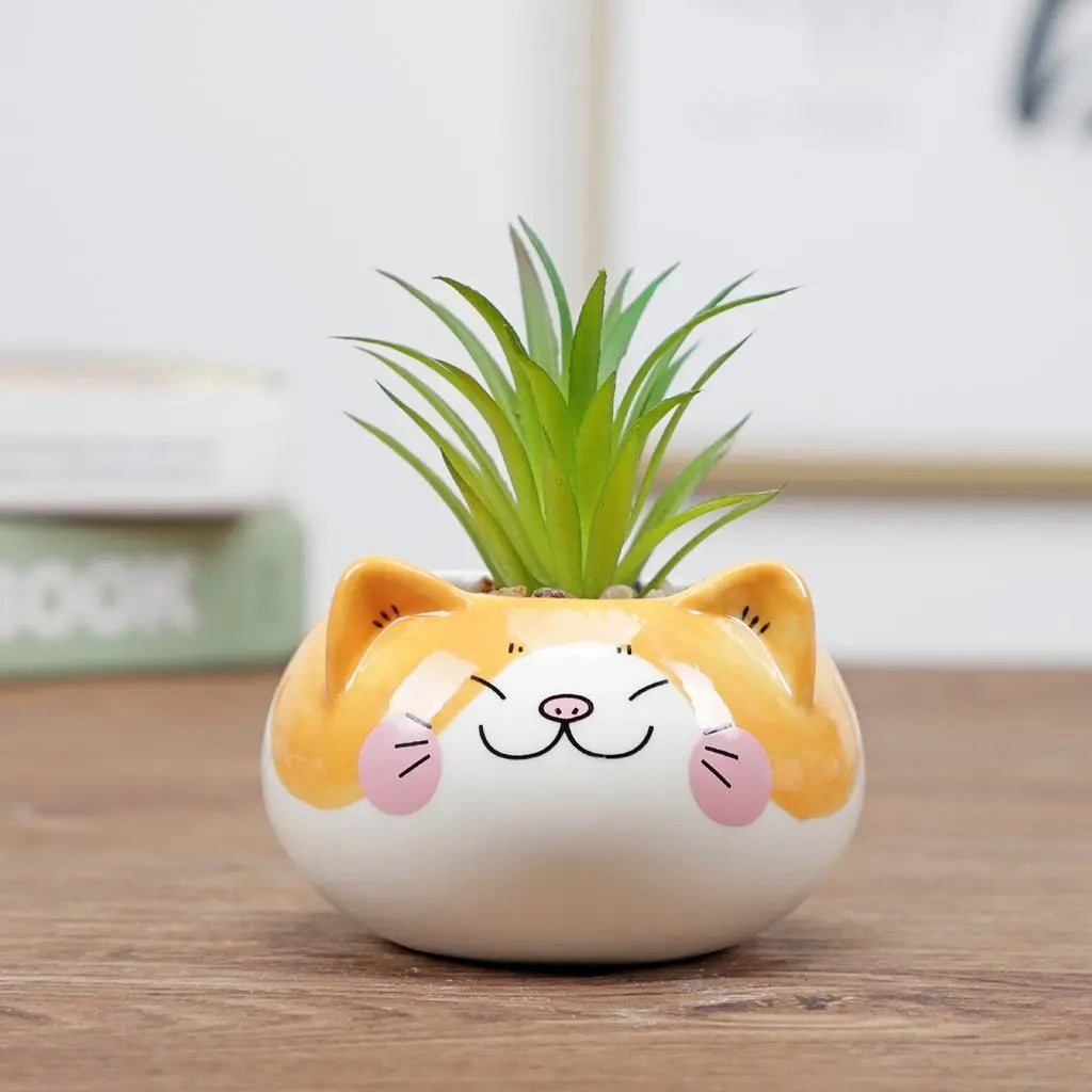 Round yellow-and-white animal-face ceramic planter with green succulent plant