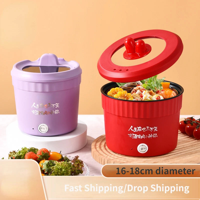 Red electric mini hot pot with lid, holding noodles and vegetables inside