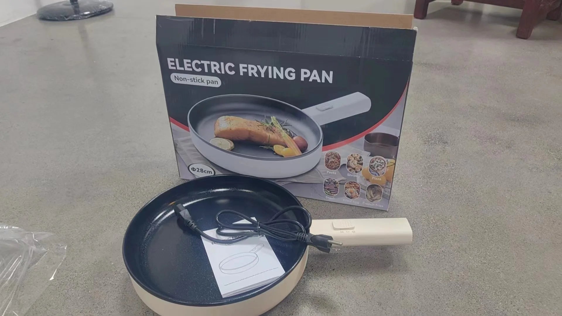 Electric frying pan with product box and power cord on countertop