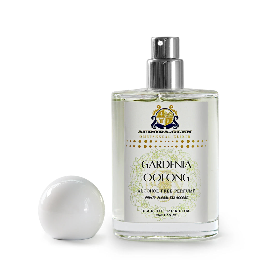 Clear glass bottle of Gardenia Oolong alcohol-free perfume with white spherical cap and floral label on white background.