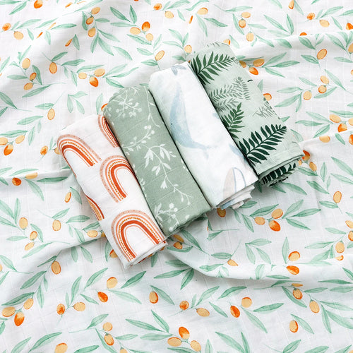Set of 4 soft muslin baby swaddle blankets with rainbow, floral, whale, and fern prints on olive branch background.