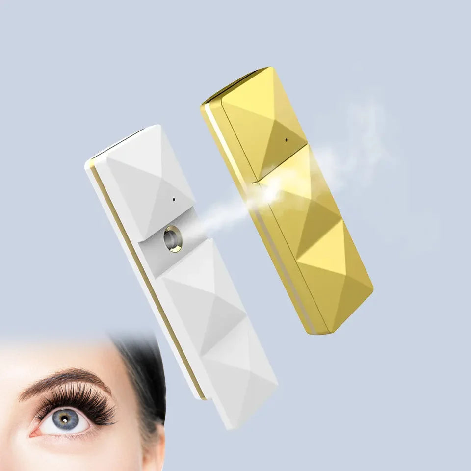 White and gold portable nano facial mist sprayers for skin hydration and eyelash extension care, USB rechargeable.