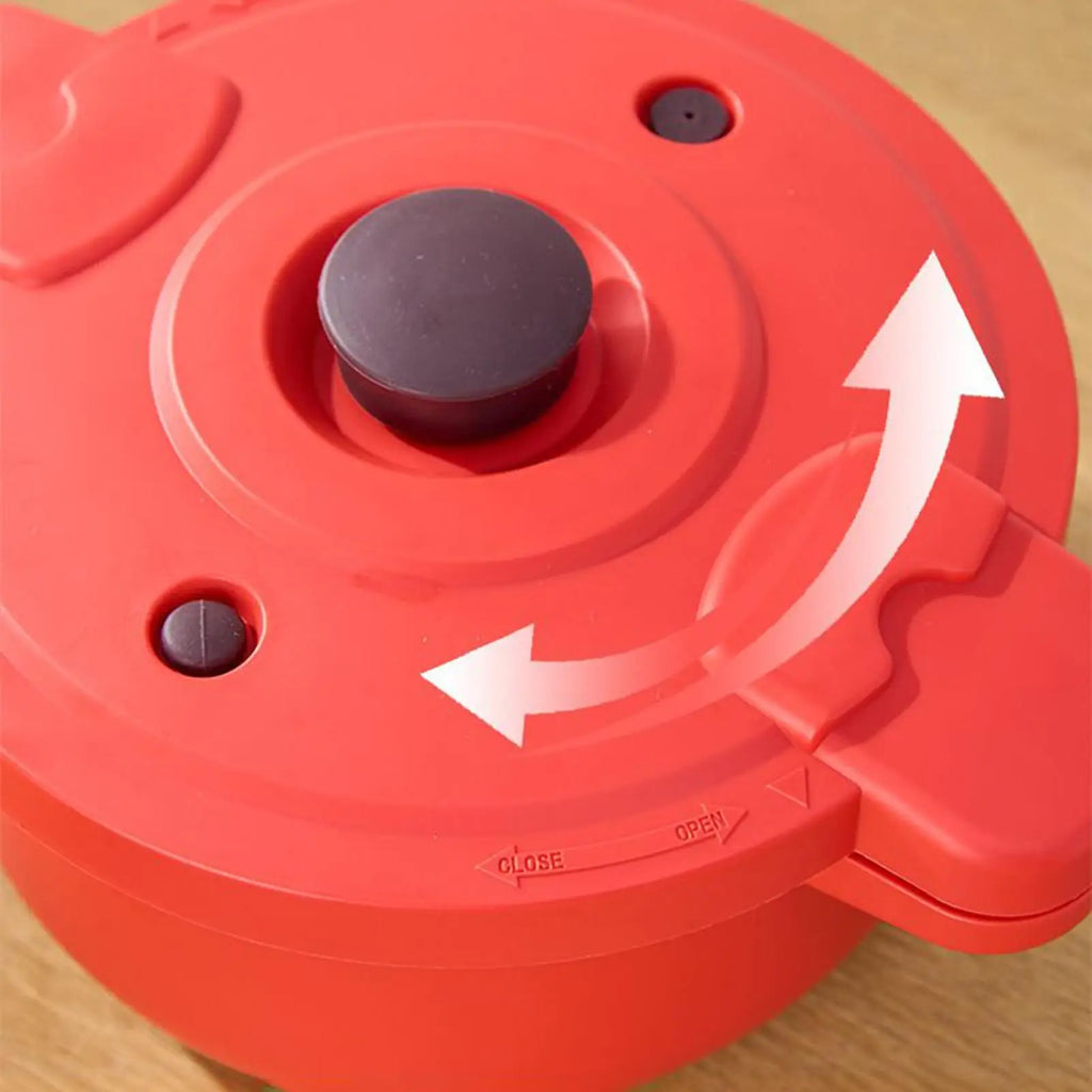 Red pressure cooker lid with pressure valve knob and vent arrows