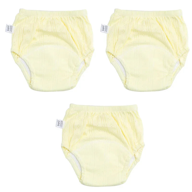 Three-pack of yellow UoU baby care training diapers in a textured, breathable fabric design.