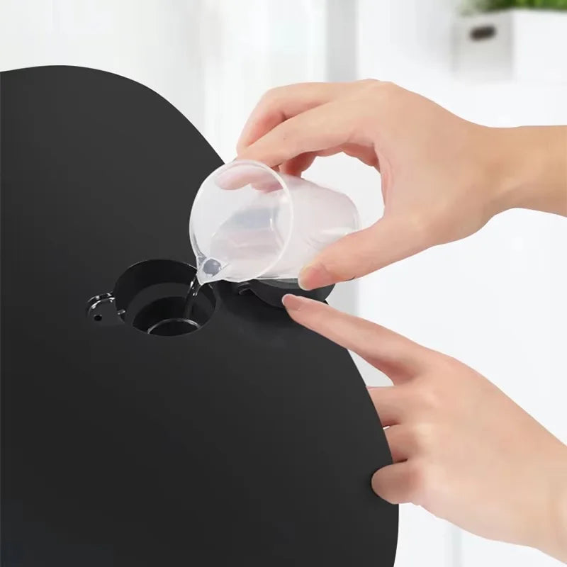 Hand pouring water into a black 7-color PDT LED light therapy facial mask for skincare and acne treatment.