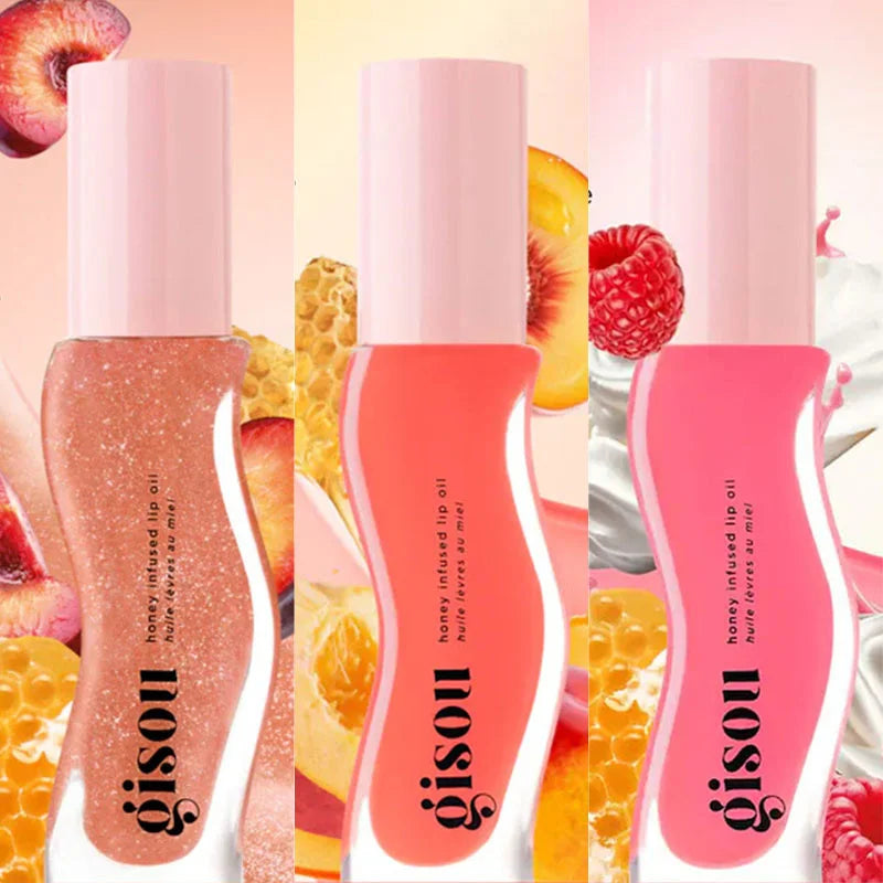 Gisou Honey Infused Lip Oil trio in glazed plum, peach, and raspberry shades with glossy, hydrating plumping texture.
