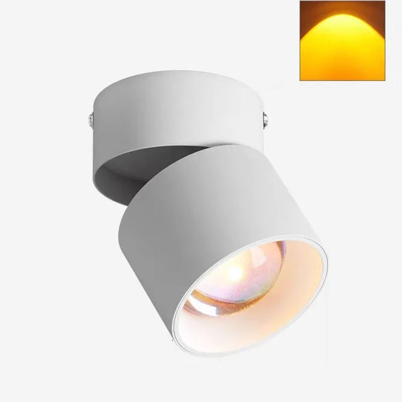 White LED ceiling surface spotlight with angled cylindrical head and warm illuminated interior