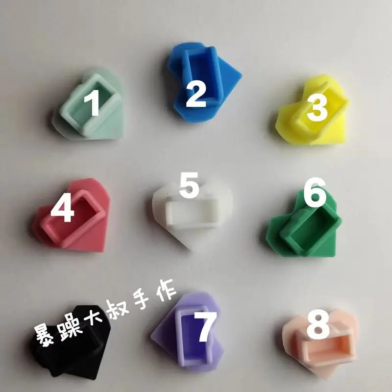 Colorful heart-shaped silicone dust plugs for Tamagotchi Uni, perfect for protecting charging ports from debris.