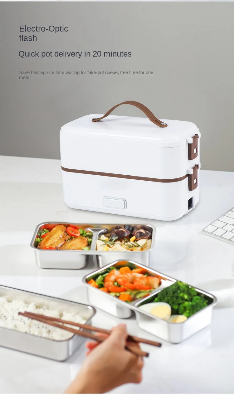 Portable electric heating lunch box with open front and stainless meal trays on table.