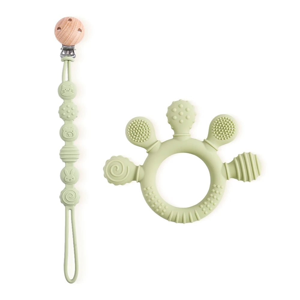 Sage green silicone baby teething ring and pacifier clip toy set for infant gum relief.
