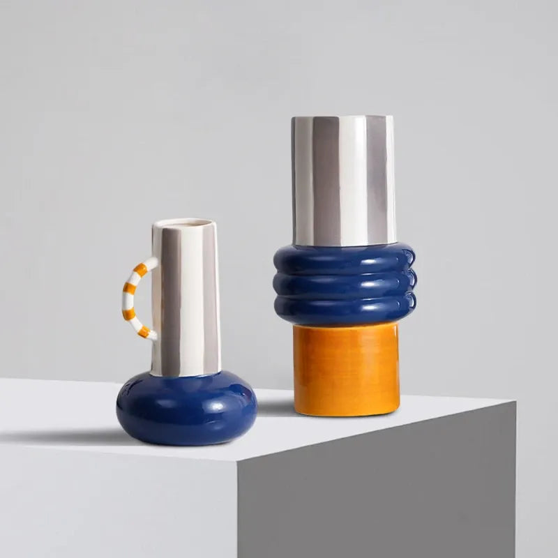 Two ceramic patchwork vases with shiny silver tops, blue necks, and orange bases