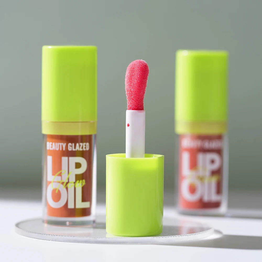 Beauty Glazed moisturizing lip oil with neon green cap and soft applicator for a lustrous, mirror-shine finish.