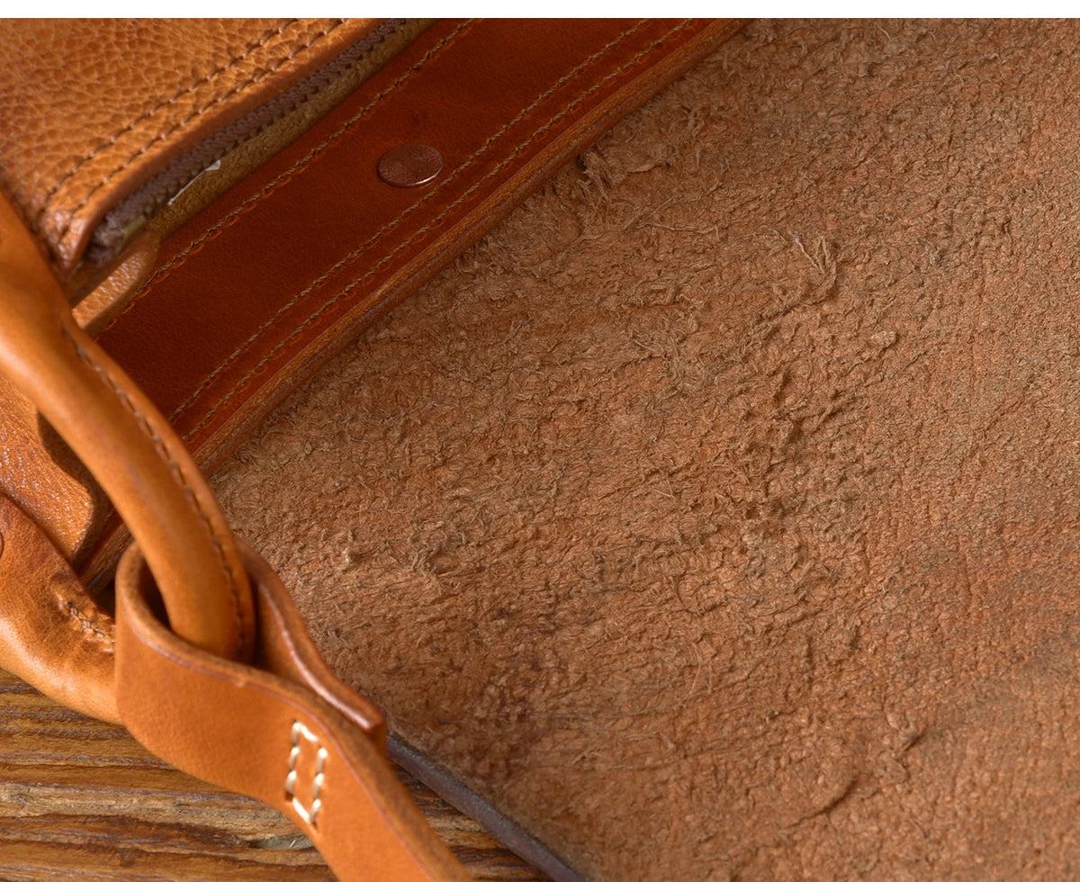 PNDME vintage handmade designer messenger bag, tan genuine cowhide leather with rugged interior texture and stitch detail.