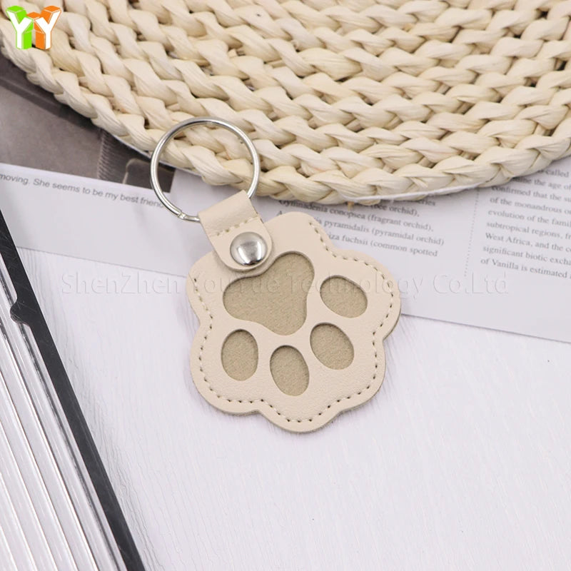 Beige leather cat paw keychain storage bag, a multifunctional pet hair container and stylish charm for bags.