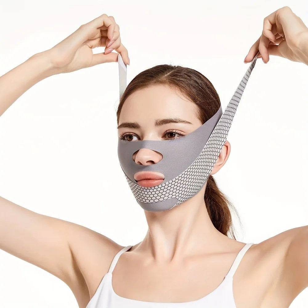A woman wears a grey, breathable V-line face slimming bandage with a honeycomb texture, securing it over her head.