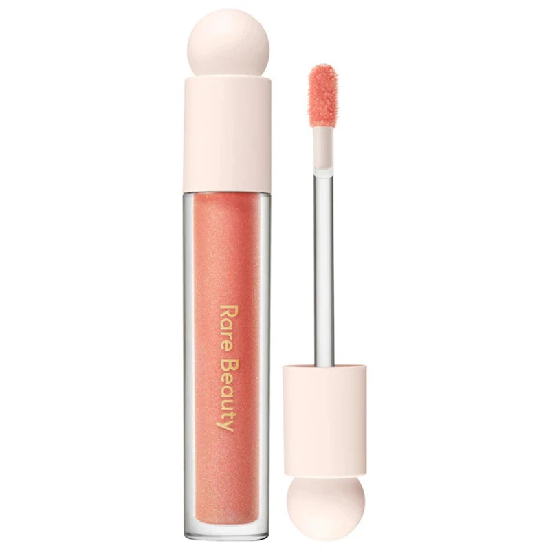 Rare Beauty Soft Pinch Tinted Lip Oil in a sheer peach shade with doe-foot applicator, moisturizing glossy finish.