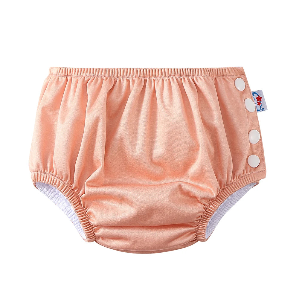 Peach baby cloth diaper with side snap buttons for adjustable fit. Premium baby care product.