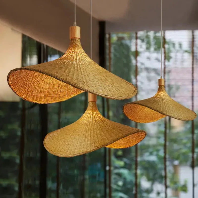 Three wide-brimmed woven rattan pendant lights with light wood accents, hanging at varying heights for ambient lighting.