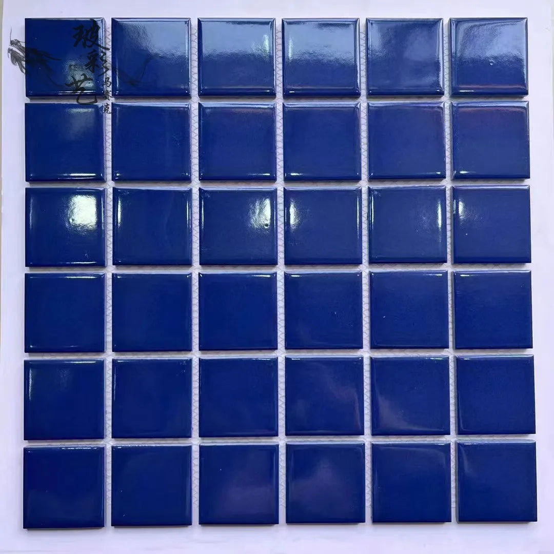 Ceramic mosaic tiles in glossy blue square pattern, close-up wall panel.