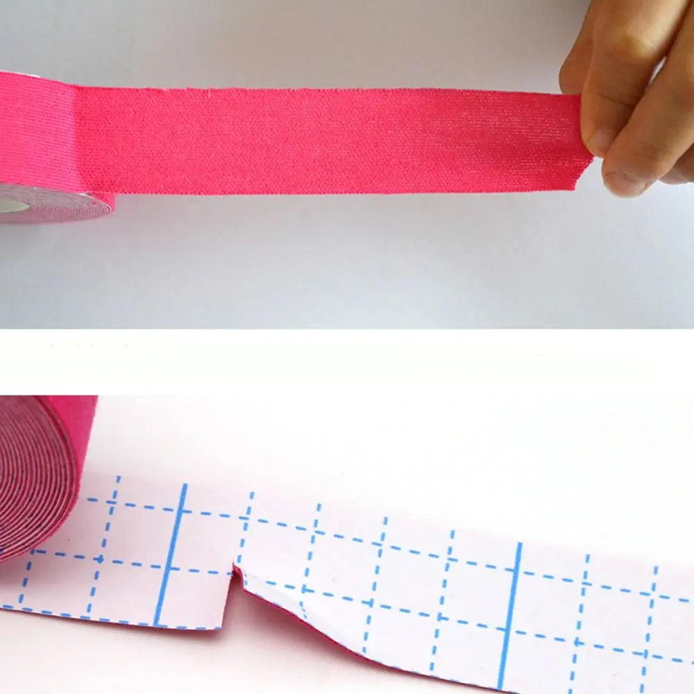 Bright pink, fabric-textured facial toning tape being pulled from a roll with a blue-gridded paper backing.