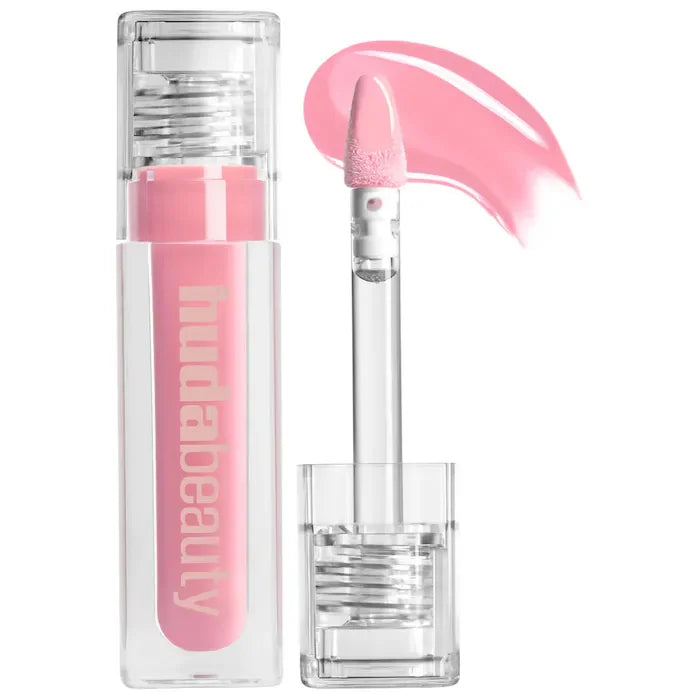 Huda Beauty hydrating lip and cheek tint stick in soft pink with applicator wand and smooth cream texture.