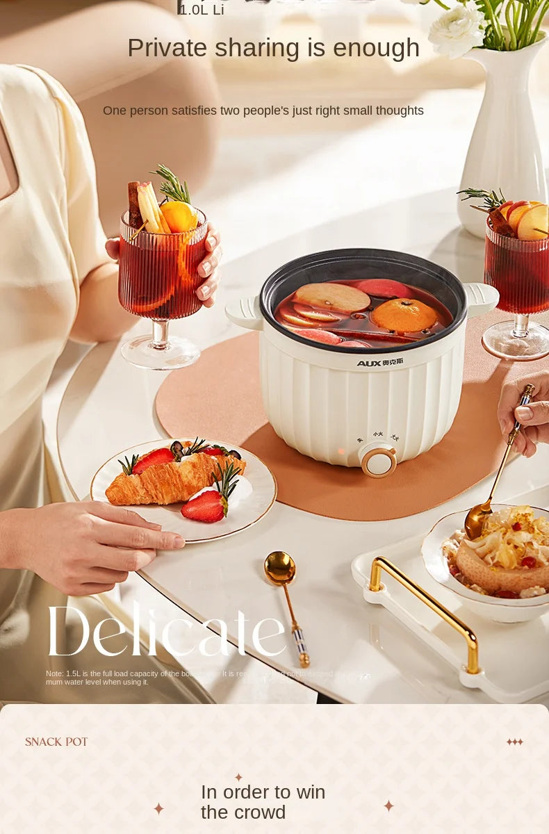 Mini electric hot pot cooker with glass lid on table with served food