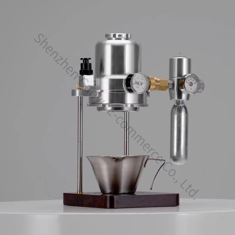 Stainless steel manual espresso maker with pressure gauges, brass fittings, and dark wood base on a white surface.