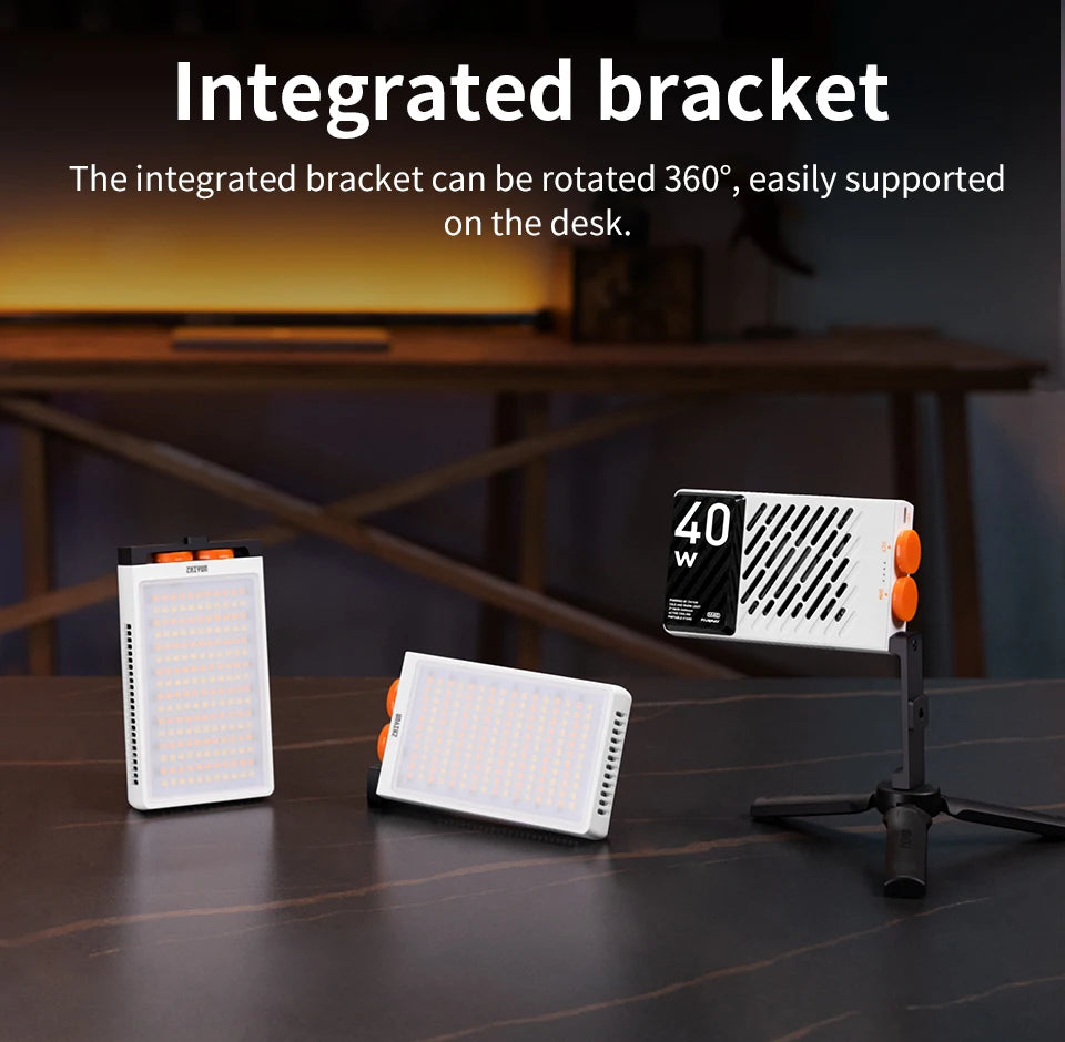 Three rectangular LED video lights with white casing, orange accents, and integrated 360-degree rotating desk stands.