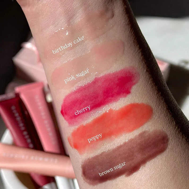 Summer Fridays moisturizing lip balm set swatches: glossy, pigmented shades from clear to brown on skin.