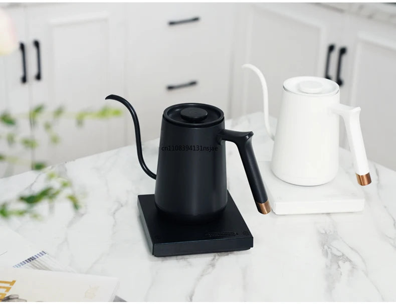 Modern matte black and white stainless steel gooseneck electric kettles with rose gold accents on a marble counter.