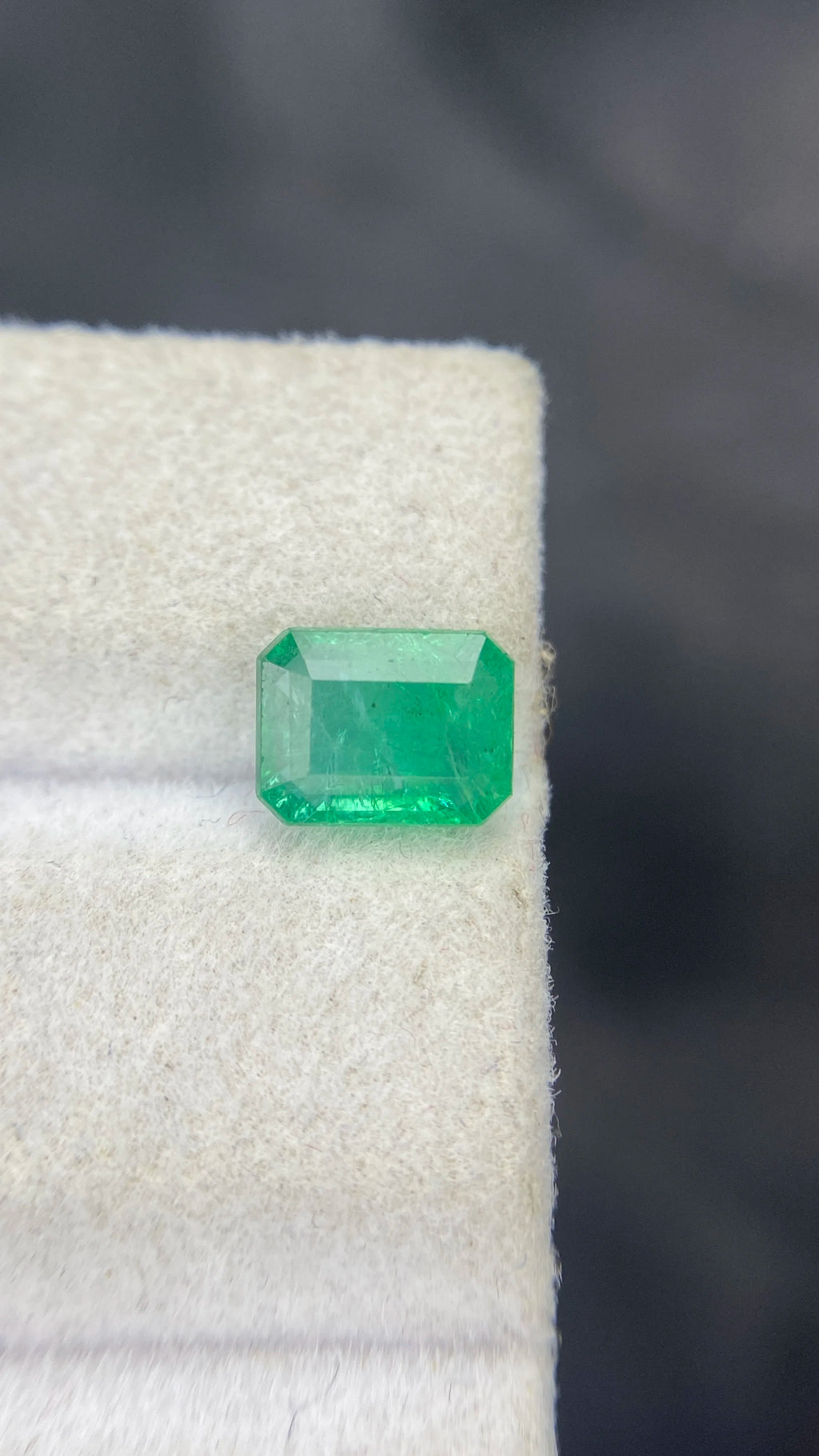 Loose green emerald-cut gemstone, rectangular with step facets