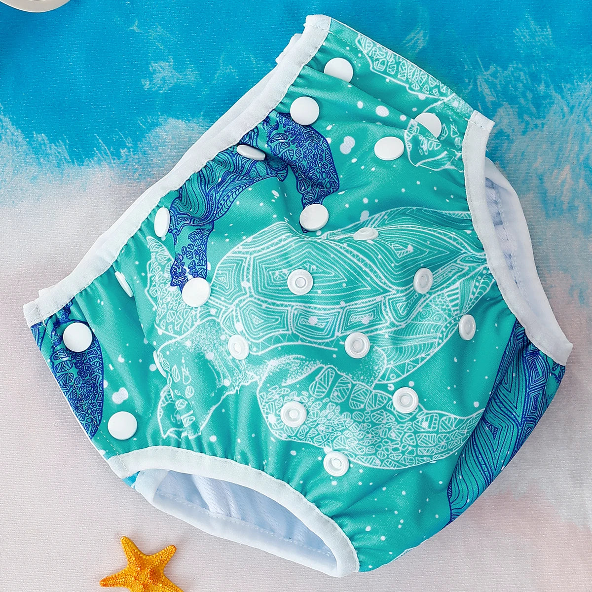 Reusable adjustable baby swim diaper in teal turtle print with snap closures for a secure, comfortable fit.