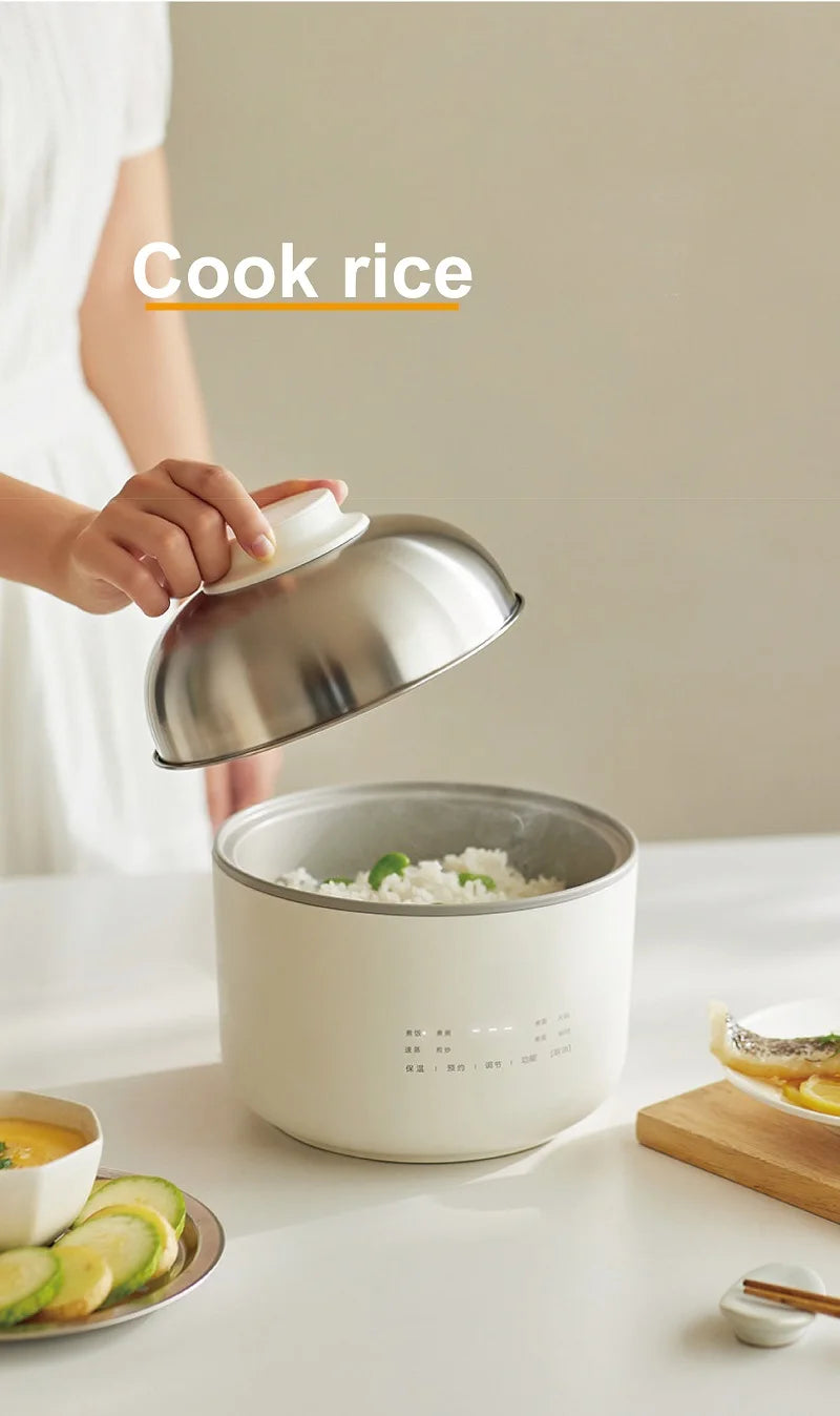 1.5L electric rice cooker with lid, hands scooping rice with a spoon