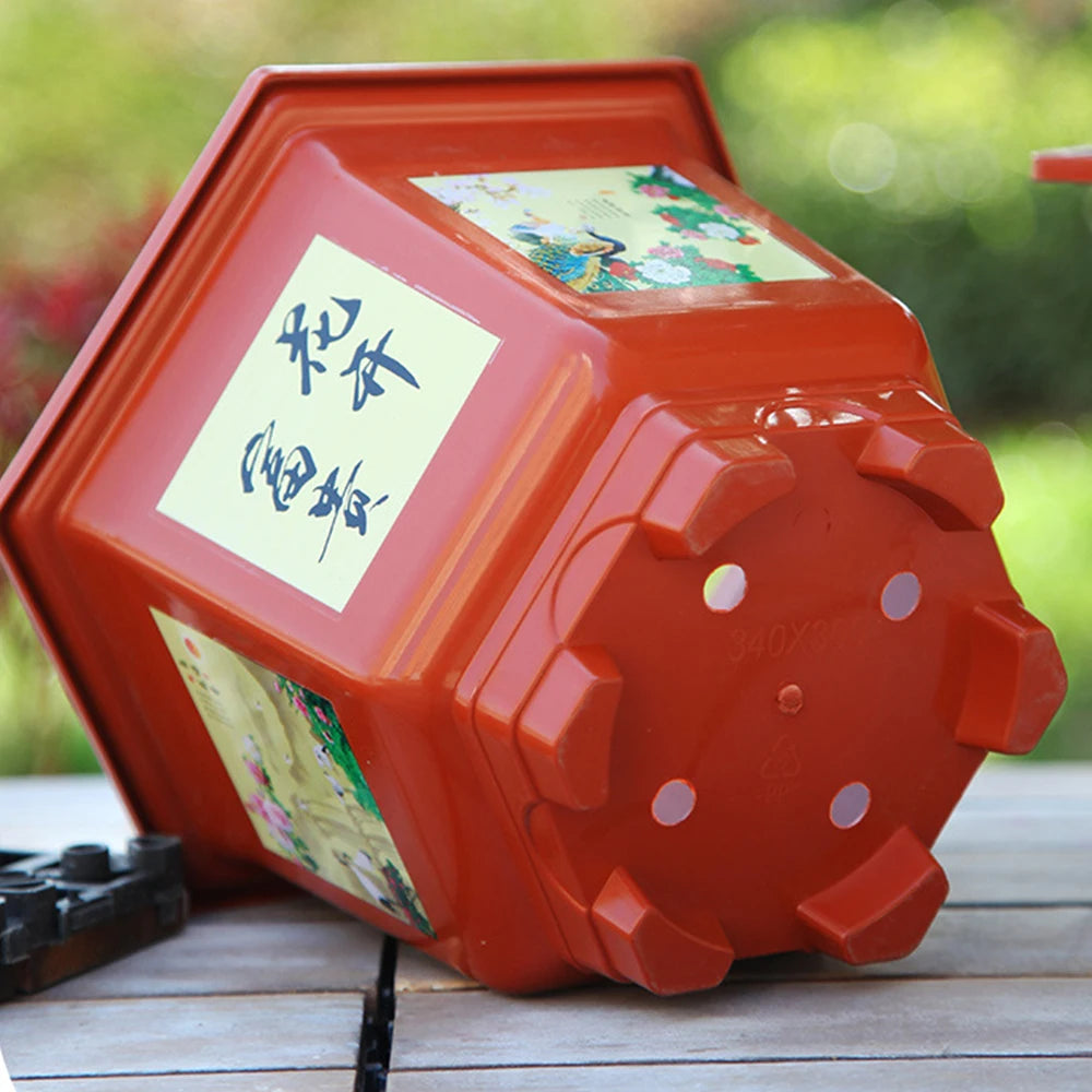 Close-up of a red resin flower pot top and side with illustrated label panel and knobs.