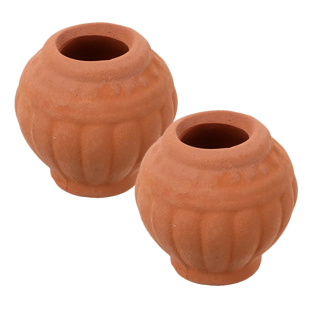 Two small terracotta clay planter pots with dark inner openings and drainage holes