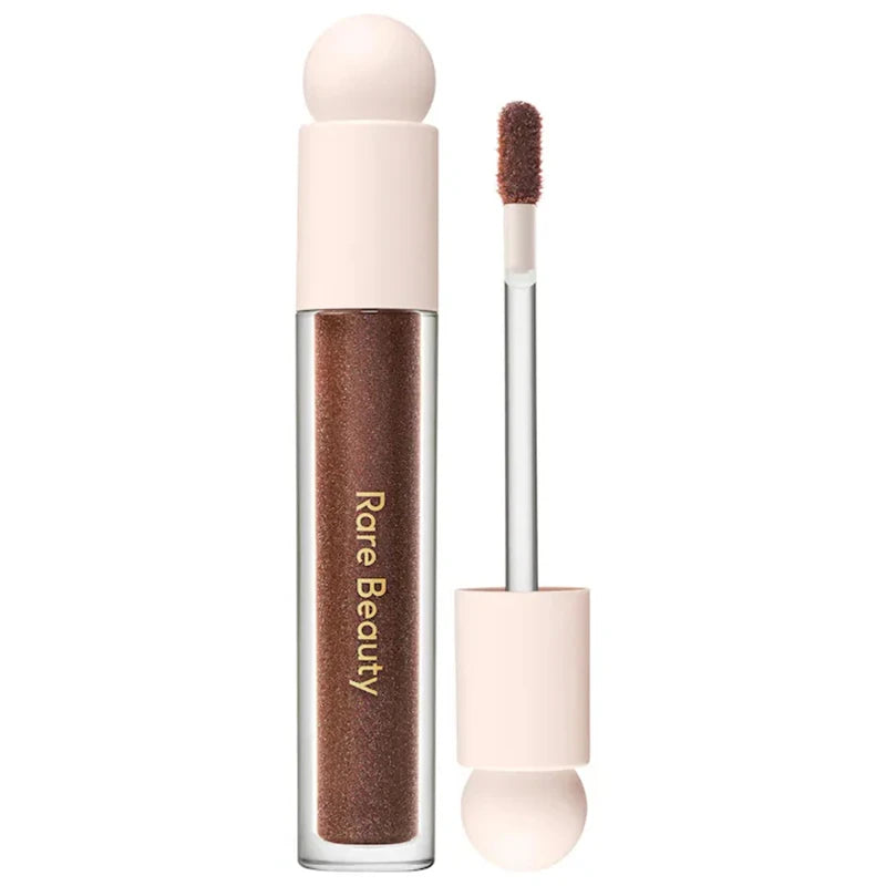 Rare Beauty Soft Pinch Tinted Lip Oil in a deep brown shade with applicator wand, featuring a glossy, moisturizing finish.