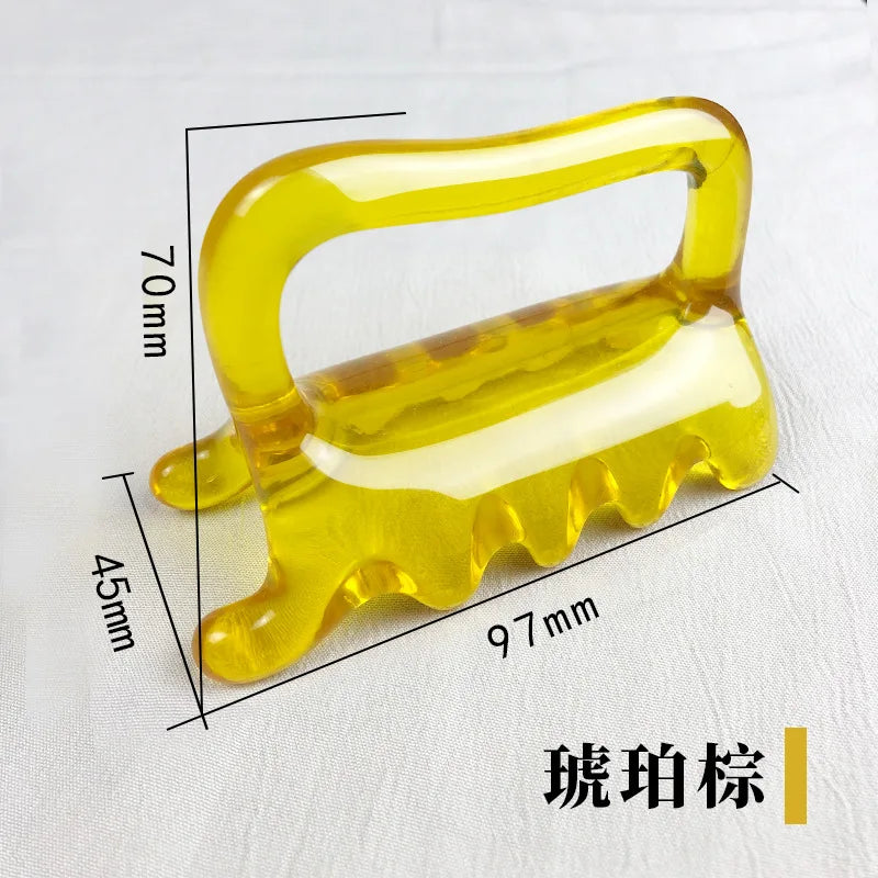 Yellow amber-colored resin massage tool with a curved handle and five-point comb base. Measures 97mm by 70mm by 45mm.