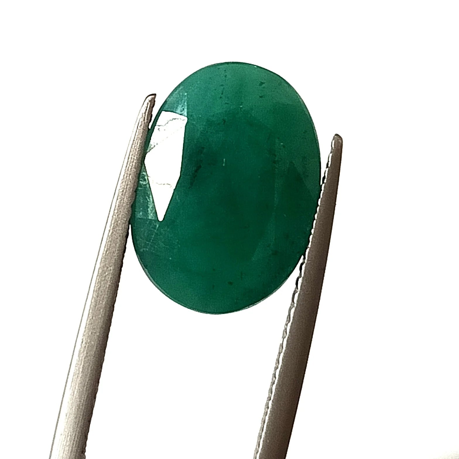 Oval green emerald gemstone, faceted loose cut, upright view in tweezers