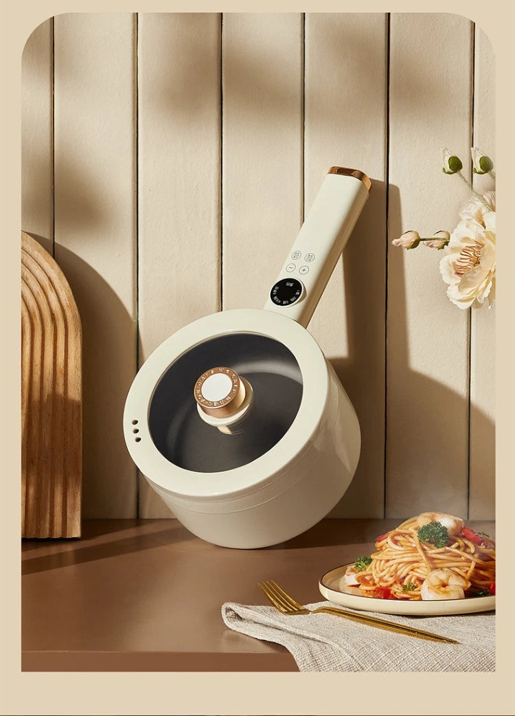 White electric hot pot with lid on countertop next to cooked noodles and dishes
